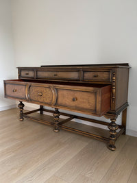 Vintage 1920s Berkey and Gay Sideboard Buffet Server Table - Jacobean Style The sideboard is supported by Baroque-style turned legs along the front with bun feet. It has a small backsplash on the backing.