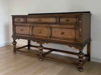 Vintage 1920s Berkey and Gay Sideboard Buffet Server Table - Jacobean Style The sideboard is supported by Baroque-style turned legs along the front with bun feet. It has a small backsplash on the backing.