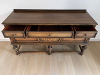 Vintage 1920s Berkey and Gay Sideboard Buffet Server Table - Jacobean Style The sideboard is supported by Baroque-style turned legs along the front with bun feet. It has a small backsplash on the backing.