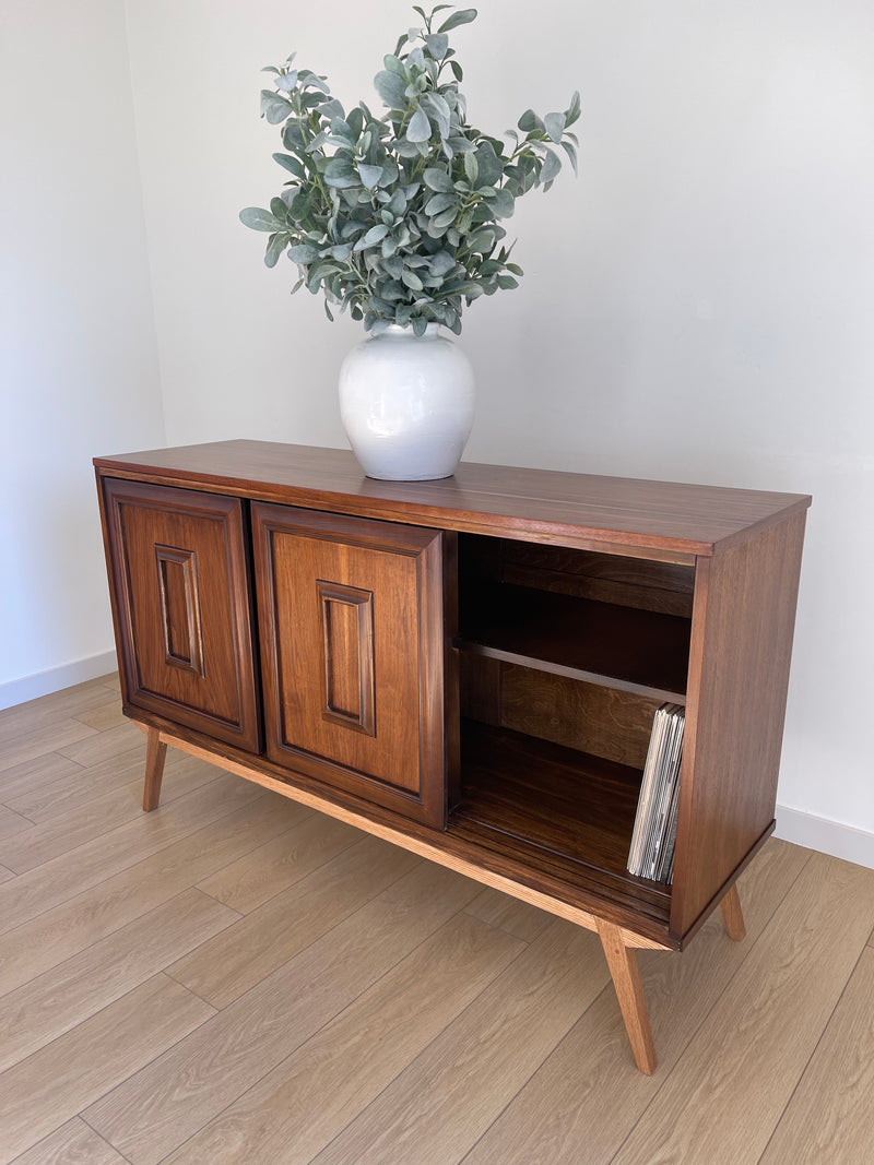 Vintage Mid Century Modern MCM Walnut Sculptural Slide Front Credenza Sideboard with Shelves. Perfect mid-century piece for an entertainment center, vinyl record storage, dresser, sideboard or sofa table. The legs are a mcm sculptural design made of solid oak. 