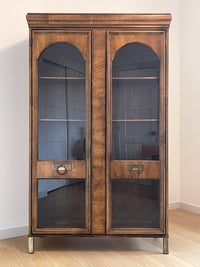 This beautiful art-deco arched glass and wood bookcase or curio cabinet is manufactured by the reputable B.P. John from Portland, Oregon. This piece is in such beautiful condition and the amazing arched doors and original brass hardware is a show-stopper for any style of home, office or commercial space. 