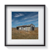 An abandoned tin and wood farm shed in the dried fields of South Dakota. Framed fine art shack and rustic photography by Andrew Grant.  Framed wall art for your home, office, business, restaurant, bar, vacation house or hotel.
