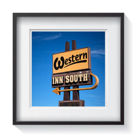 A yellow, black and brown vintage sign for the Western Inn South with blue bird skies. Framed fine art vintage sign photography by Amanda Hedlund.  Framed wall art for your home, office, business, restaurant, bar, vacation house or hotel.