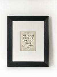 Monotype Series Perpetua Gothic Vintage Industrial Font Alphabet Graphic Framed Art Framed in a modernized black frame with white mat.  The alphabet fonts and numbers are featured on an antiqued page of type and lettering for typographers, letterers and designers published in 1950. 